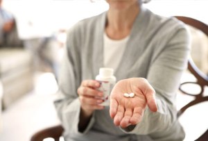 getty_rf_photo_of_woman_holding_pills